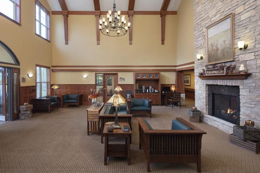 A spacious lobby with comfortable seating, a chandelier, and a fireplace.
