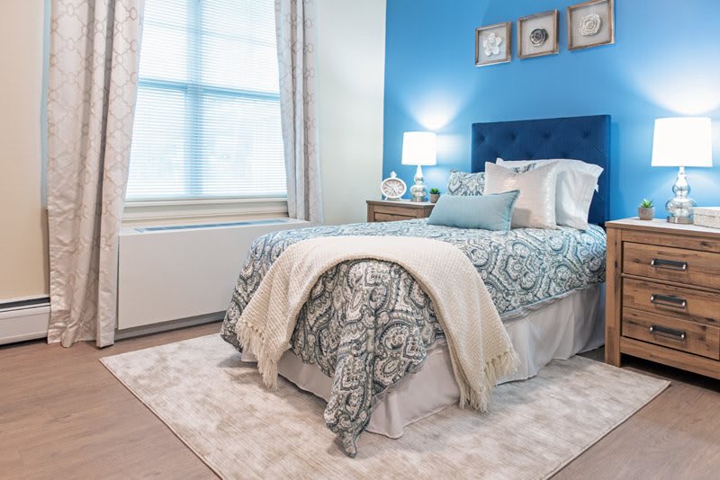 A cozy bedroom with a blue accent wall and elegant decor.