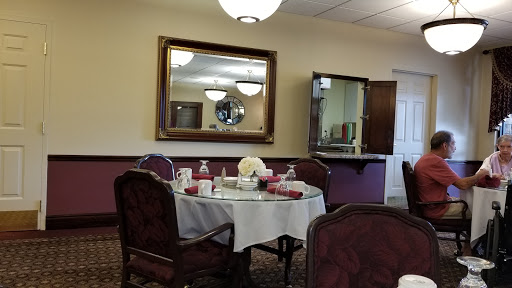 A cozy dining room with an elegantly set table and a large mirror reflecting the space.