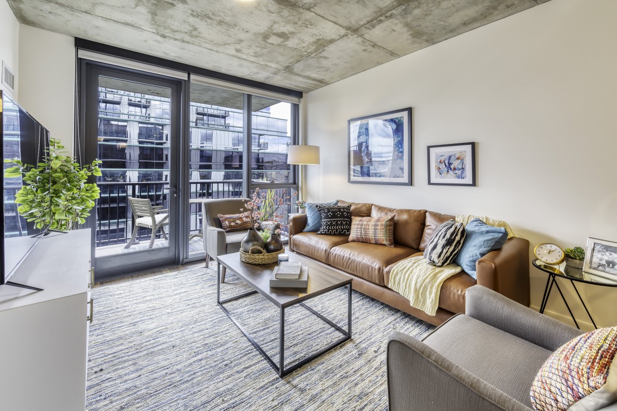 A modern living room with a cozy sofa and large windows letting in natural light.