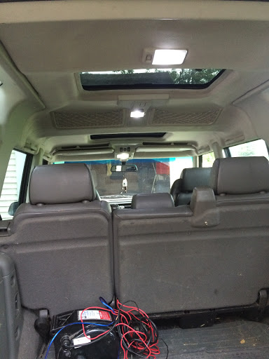 A view of the interior of an SUV from the back, showcasing the seating arrangement and sunroof.
