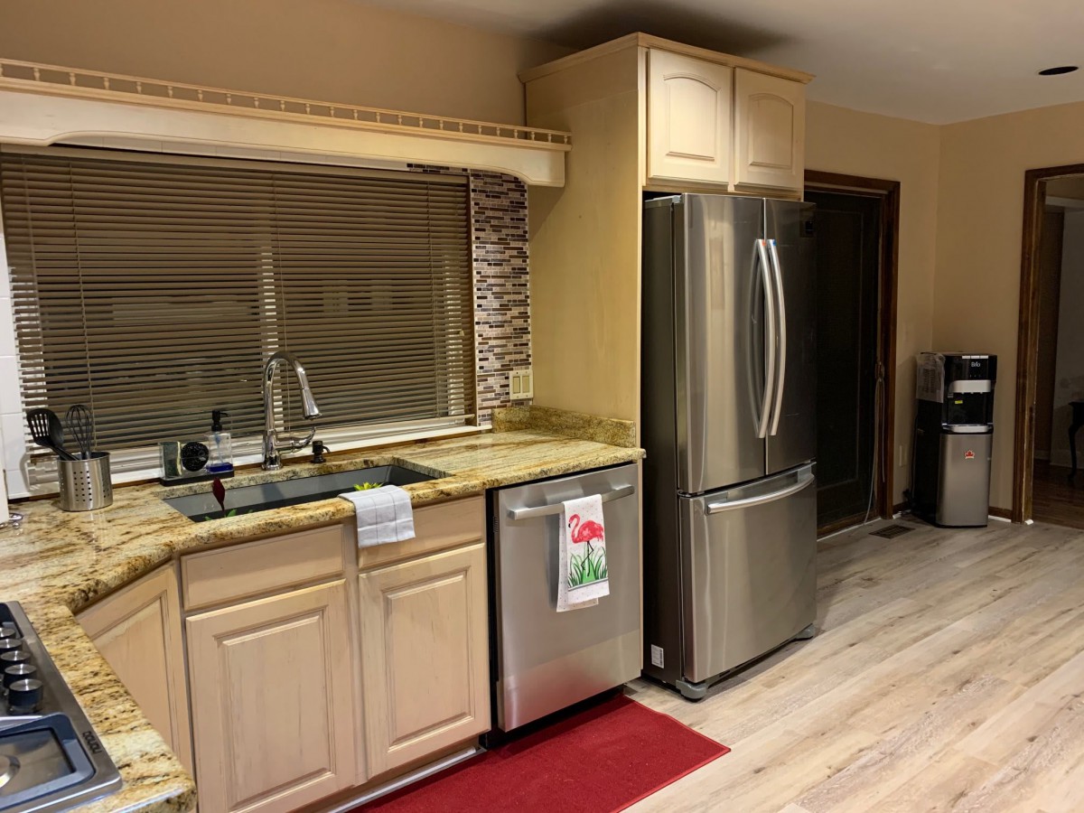A modern kitchen interior with stainless steel appliances and wooden cabinets.