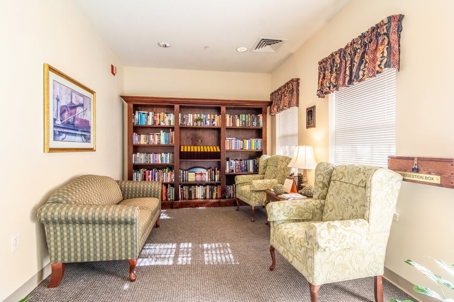 A cozy reading room with armchairs and a well-stocked bookshelf.