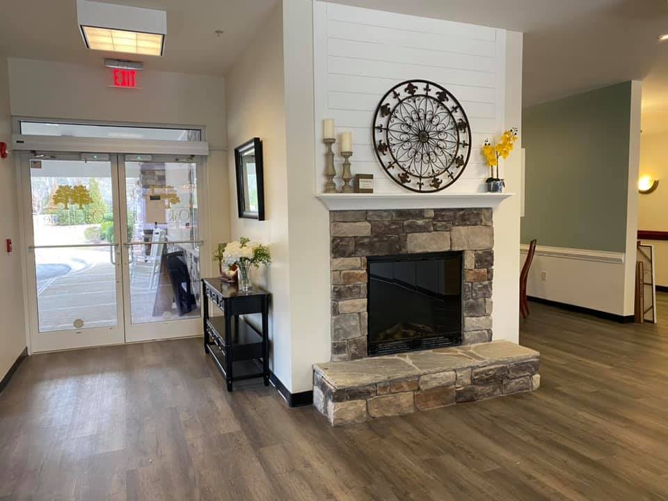A welcoming entryway with a stone fireplace and decorative clock.