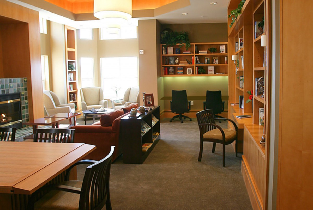 A cozy library space with comfortable reading chairs and well-organized bookshelves.