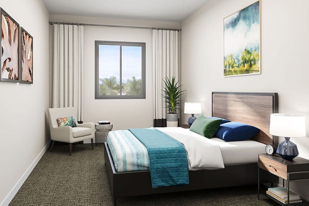 A modern, minimalist bedroom featuring a large bed with teal and white bedding, a comfortable chair, and a decorative painting on the wall.