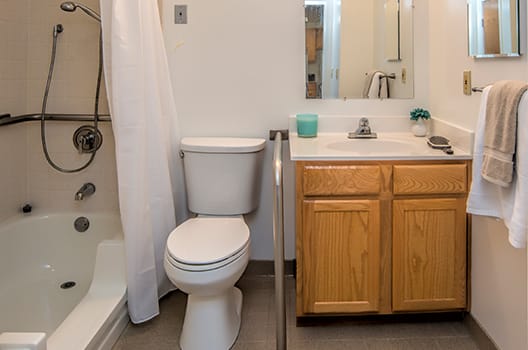 A clean and simple bathroom with a toilet, sink, and shower.