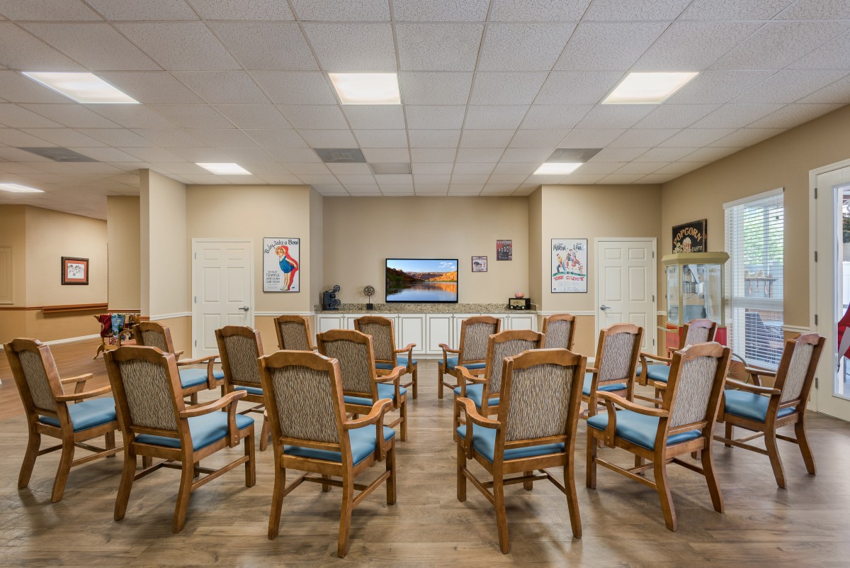 A conference room with arranged chairs facing a television.