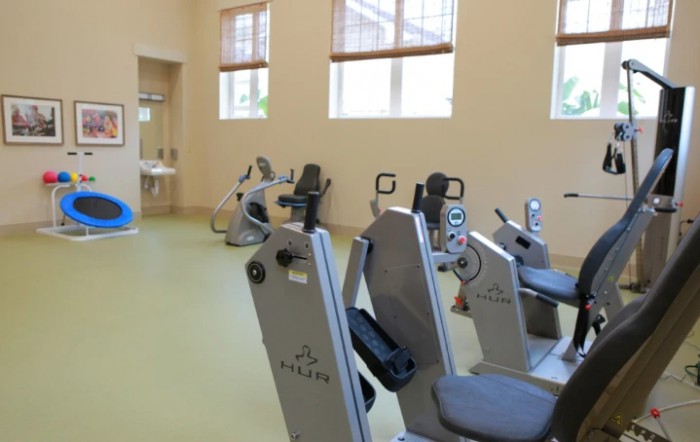 An indoor gym with stationary bikes lined up for exercise.