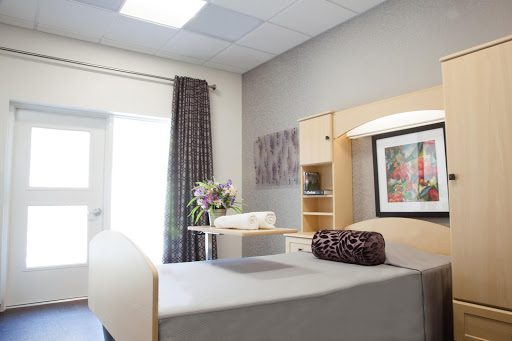 A well-furnished hospital patient room featuring a bed, bedside table, and decorative elements.