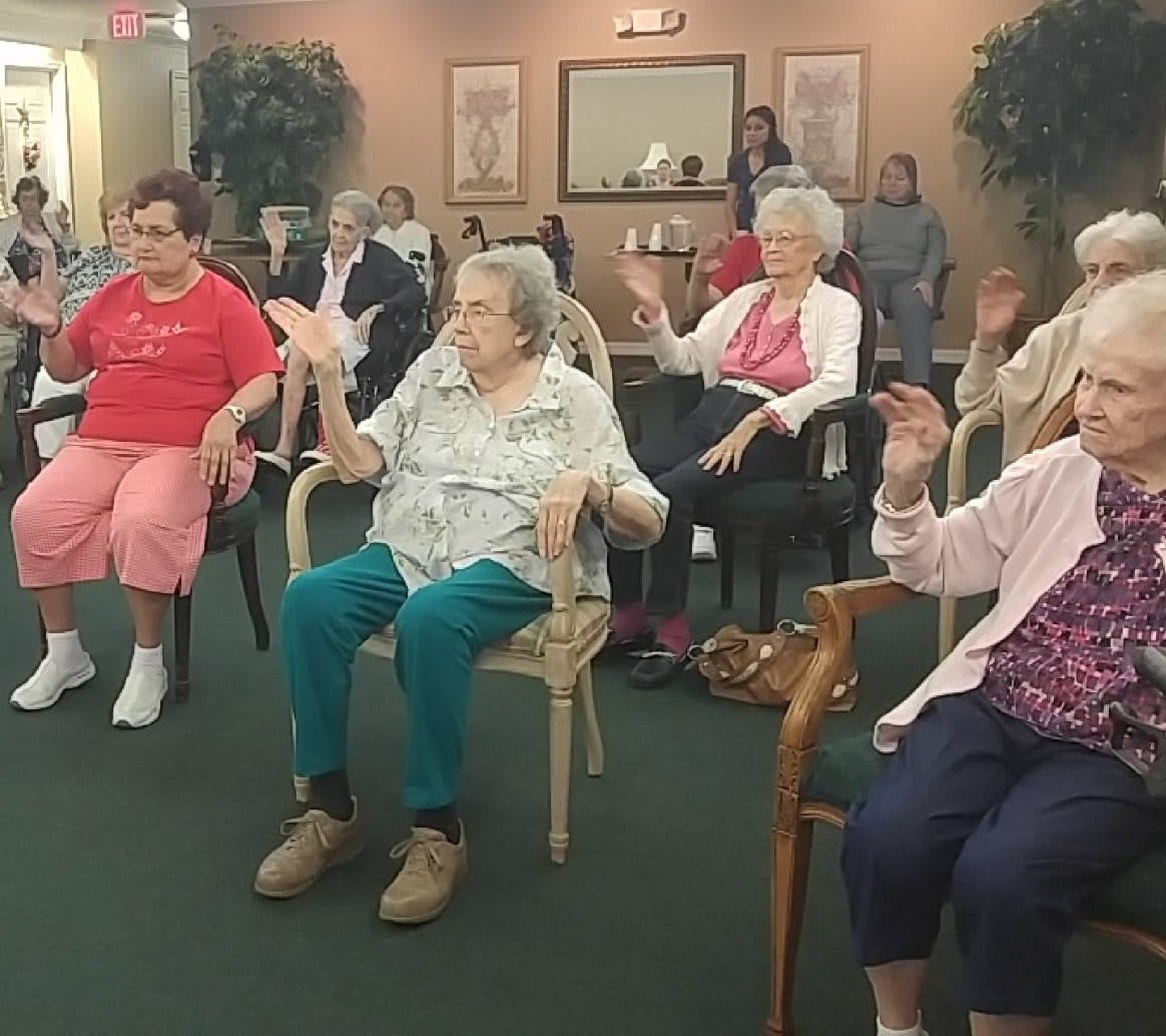 A group of seniors engaging in a seated activity indoors.