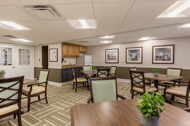 A cozy dining area with tables and chairs, decorated with wall art and plants.