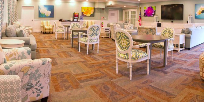 A cozy lounge area with patterned chairs and tables, accented by colorful artwork on the walls.