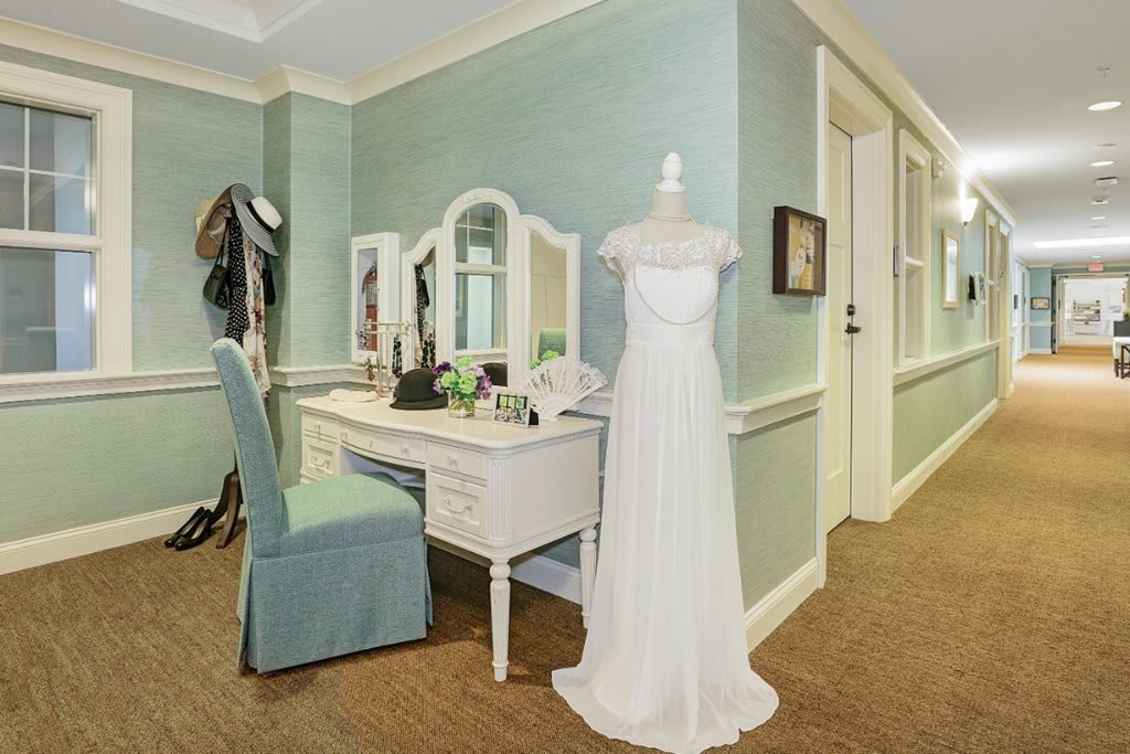A serene dressing room featuring a bridal gown on a mannequin beside an elegant vanity table.