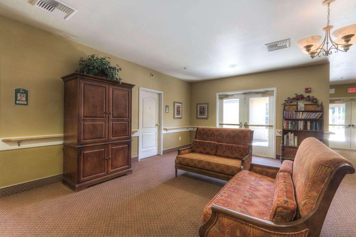 A cozy living room featuring traditional furniture, including a sofa, cabinet, and bookshelf.