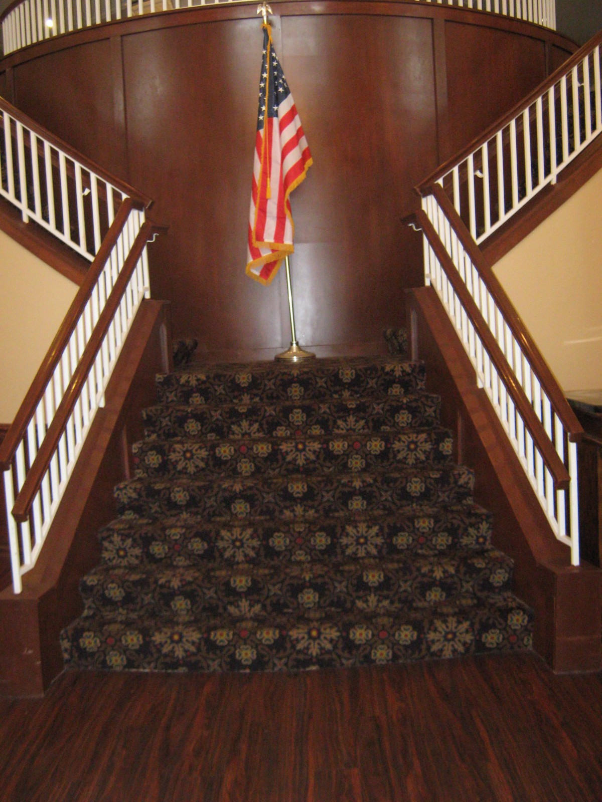 A carpeted staircase with an American flag at the top.
