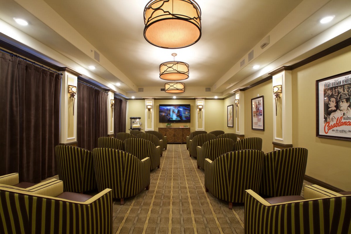 A cozy theater room with striped seating and warm lighting.