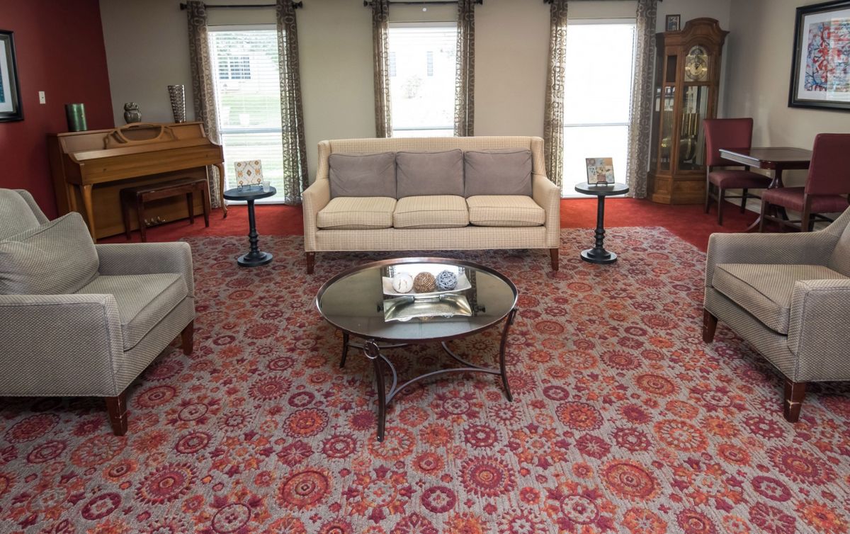 A cozy living room with a sofa, coffee table, and decorative carpet.