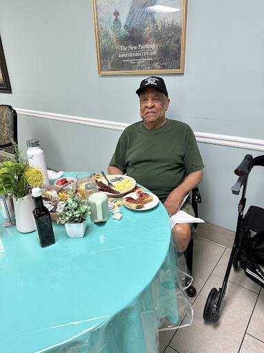 An elderly man enjoying a meal at a dining table.