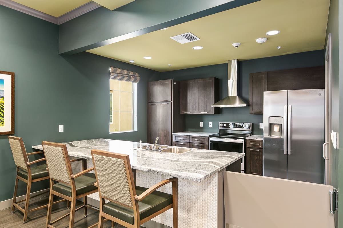 A modern kitchen with sleek cabinets, a marble countertop, and stainless steel appliances.