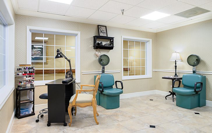 A bright office space with a desk, chairs, and windows.