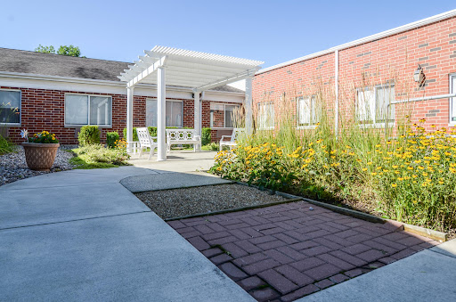 A serene garden pathway leading to a cozy outdoor seating area.