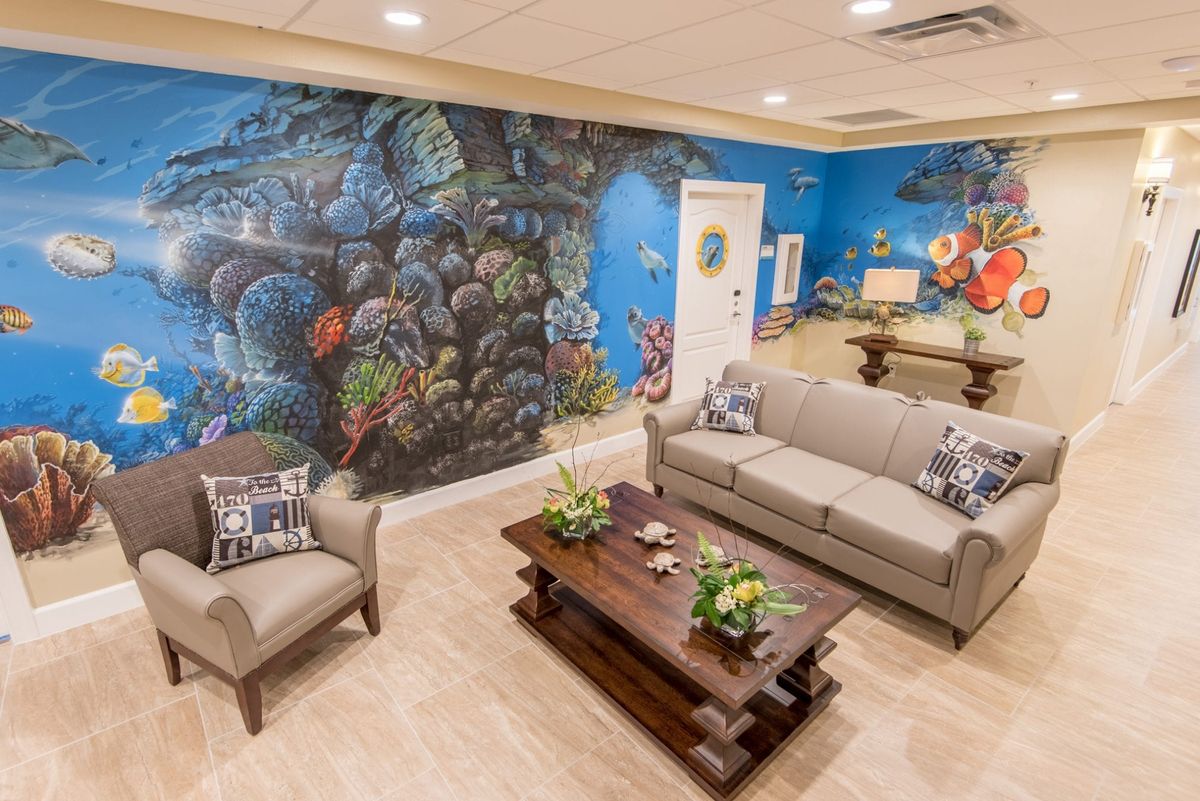 A cozy living room featuring a vibrant underwater-themed mural, with comfortable seating and decorative plants.