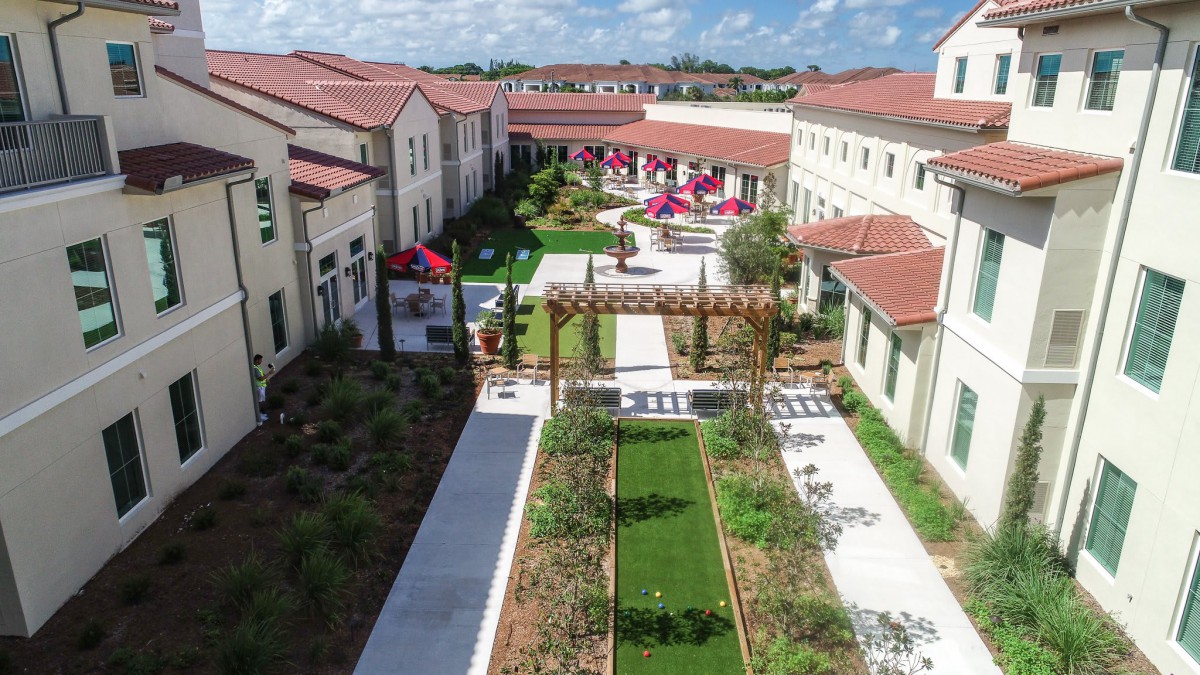 Aerial view of a beautifully landscaped courtyard surrounded by buildings with red-tiled roofs.