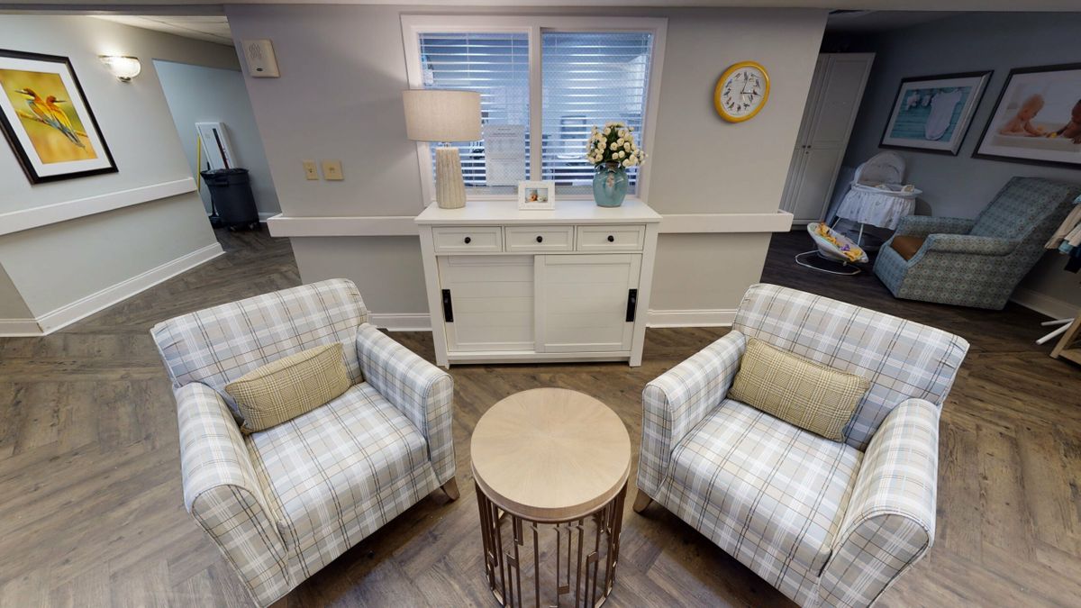 Cozy living room with plaid armchairs and a simple round coffee table.