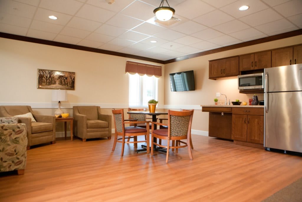 A cozy living area with a table, chairs, and a kitchenette.