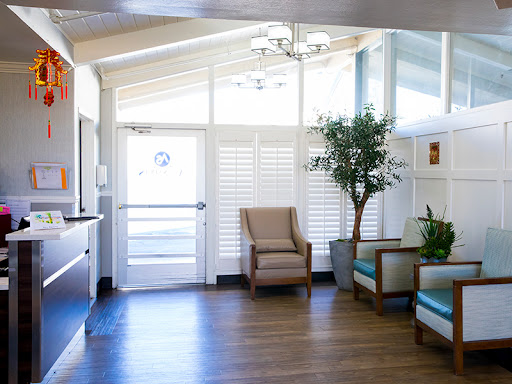 A bright and modern waiting room featuring comfortable seating and indoor plants.