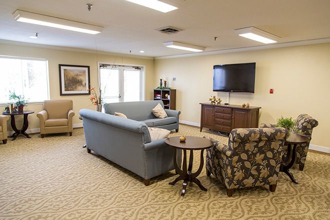 A cozy living room with sofas, an armchair, a television, and tasteful decor.