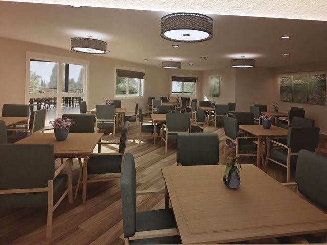 A well-lit dining room with neatly arranged tables and chairs.