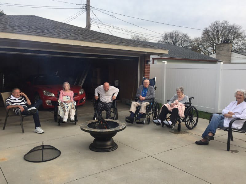 A group of seniors enjoying an outdoor gathering in a backyard setting.
