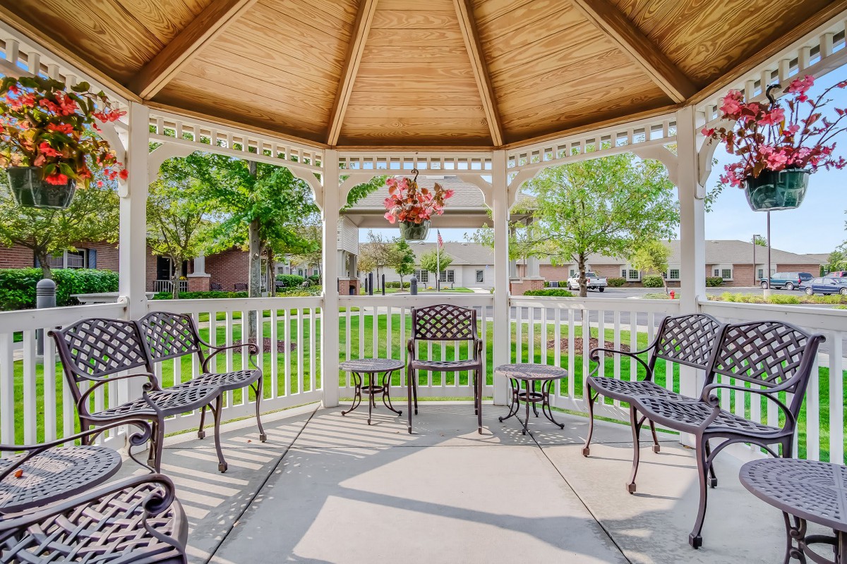 A cozy gazebo with outdoor seating on a sunny day.