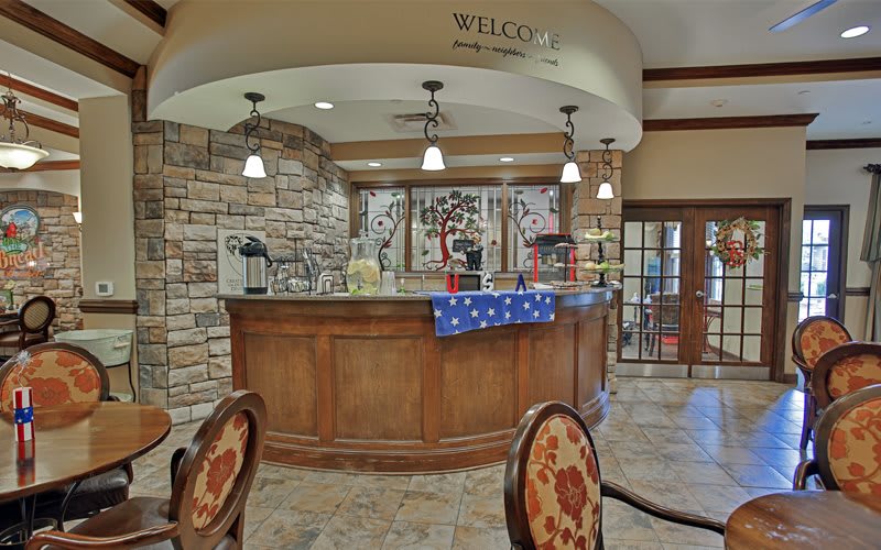 A welcoming reception area with a wooden counter and stone walls, featuring ceiling lights and decorative elements.