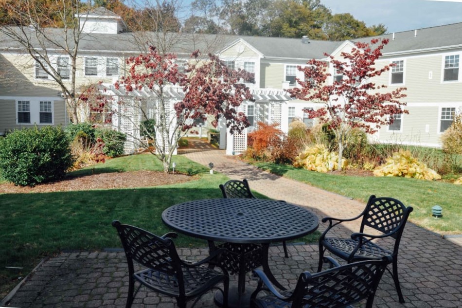 A peaceful garden patio with autumn foliage and outdoor seating.