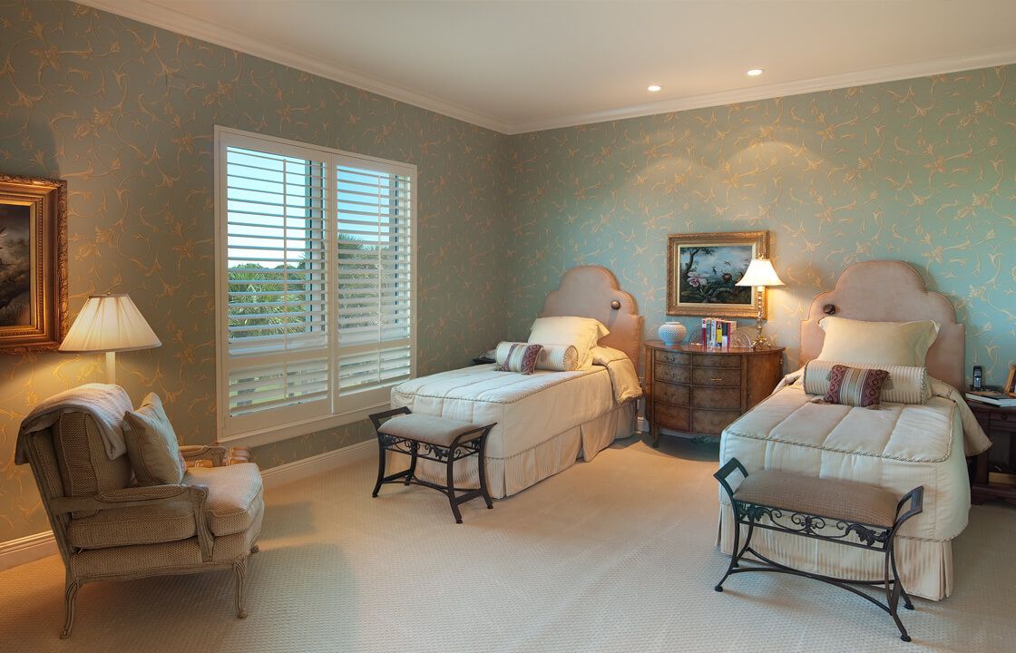 A cozy bedroom featuring twin beds, elegant decor, and soft lighting.