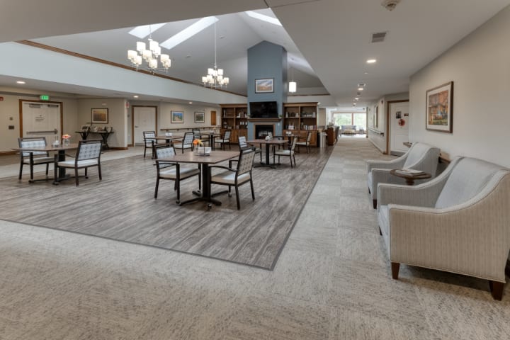 A modern and spacious lounge area featuring comfortable seating, tables, and stylish lighting fixtures.