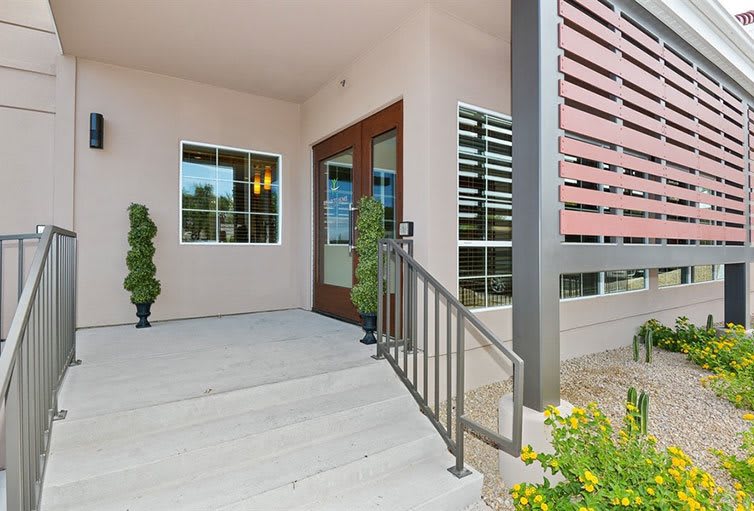 Modern house entrance with a porch and glass doors.
