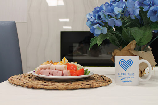 A beautifully arranged meal with fresh vegetables and a decorative flower centerpiece.