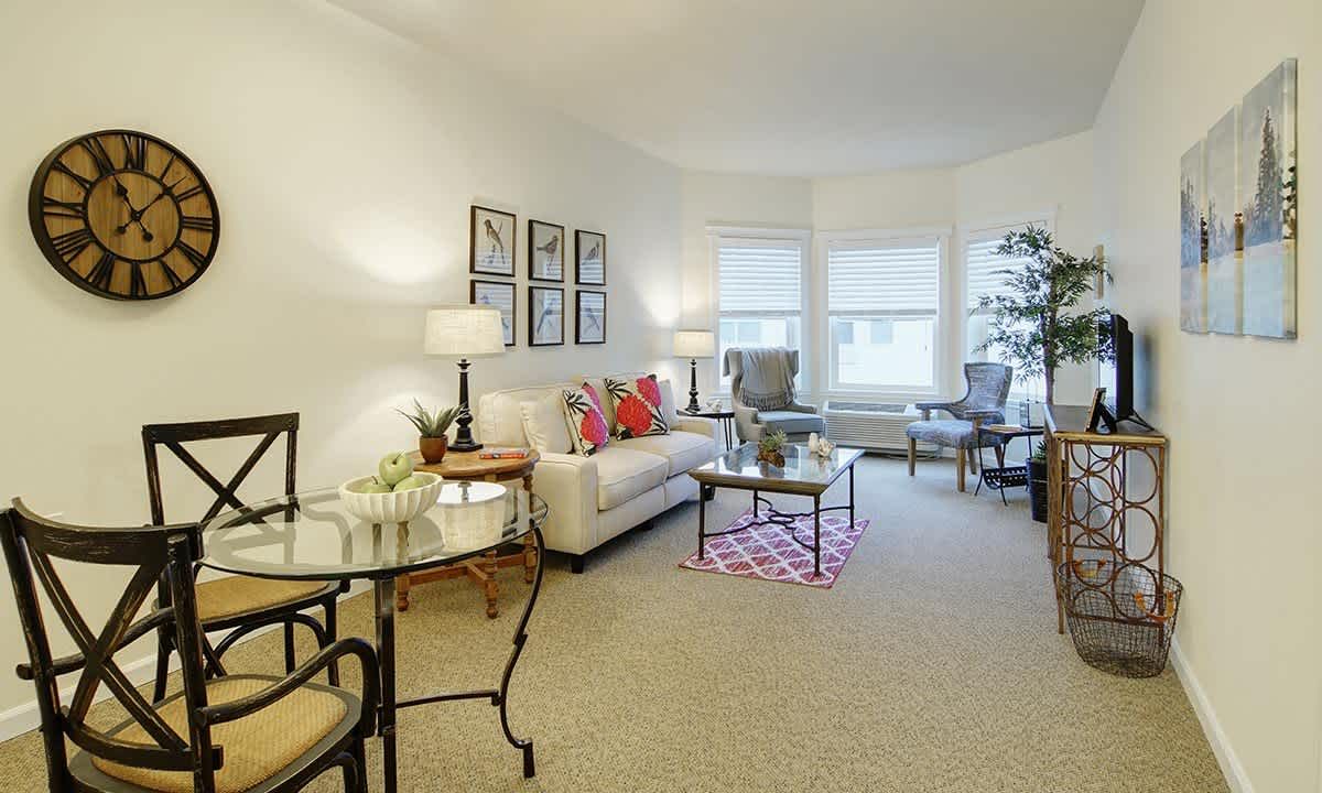 A bright and cozy living room featuring a sofa, chairs, and decorative accents.
