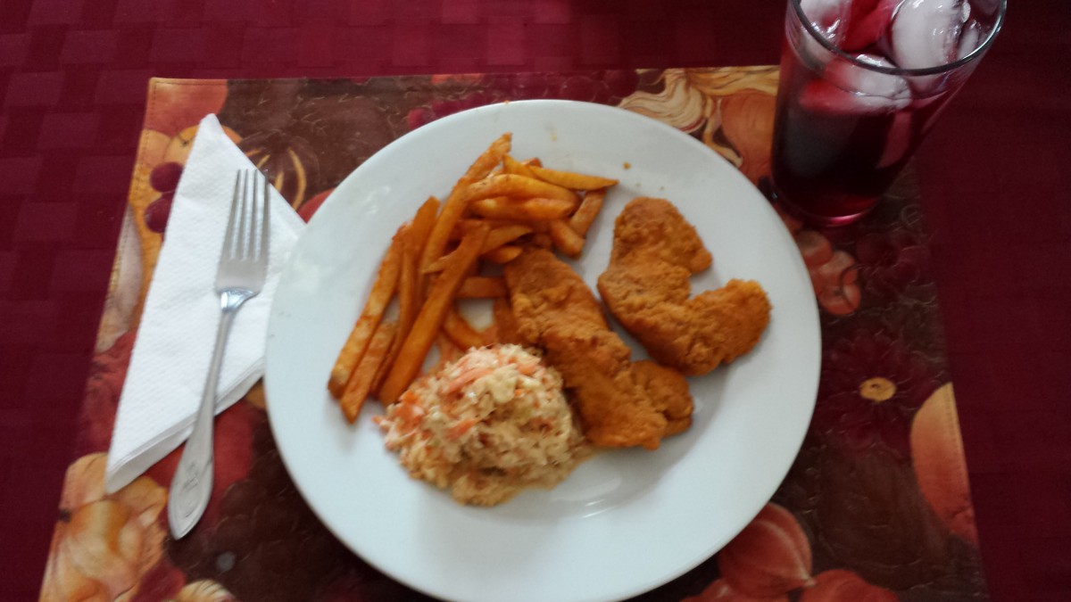 A plate with fried chicken, fries, and coleslaw.