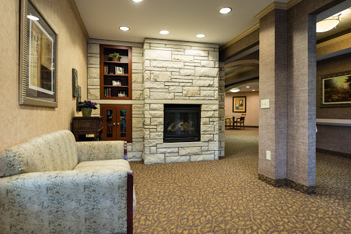 A cozy living room featuring a modern stone fireplace and comfortable seating.