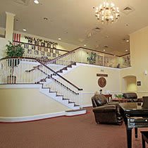 A spacious lobby featuring a grand staircase and comfortable seating area.