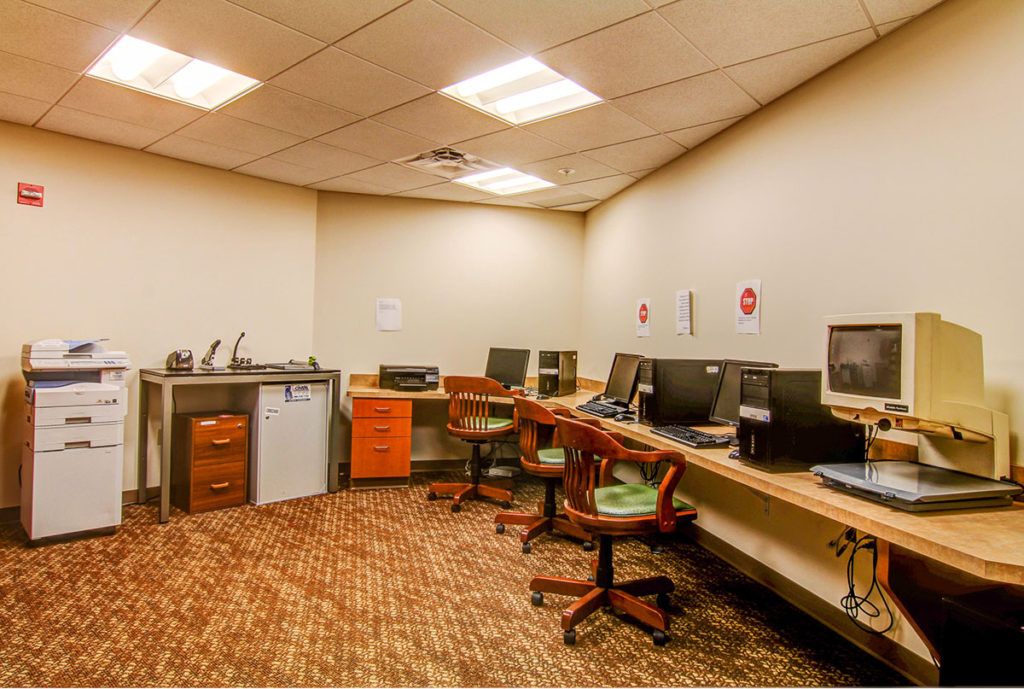 A spacious office room with multiple computer workstations and chairs.