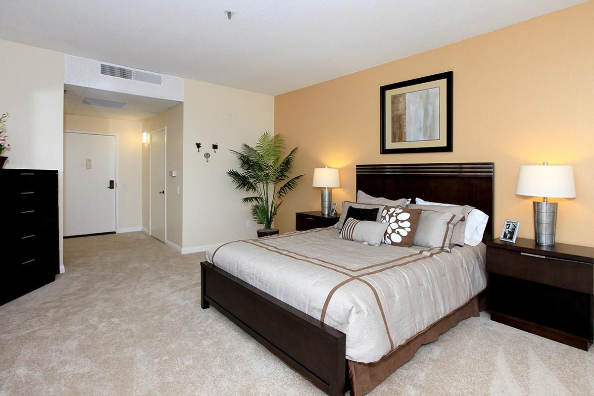 A modern bedroom with a large bed, neutral tones, and stylish decor.