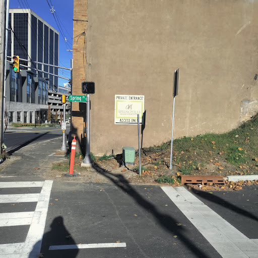 A street corner featuring a crosswalk and traffic signal, surrounded by urban buildings.
