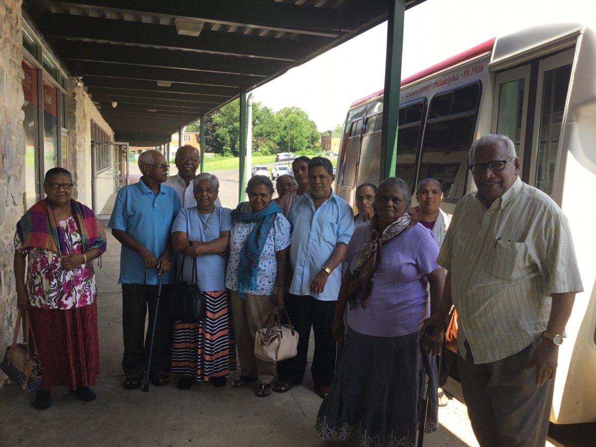 A group of elders gathered near a bus.