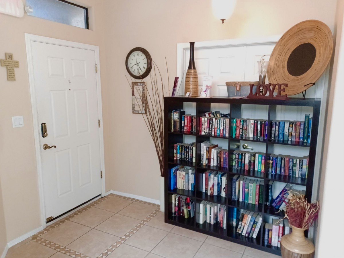 A cozy entryway featuring a bookshelf filled with books and various home decor items.